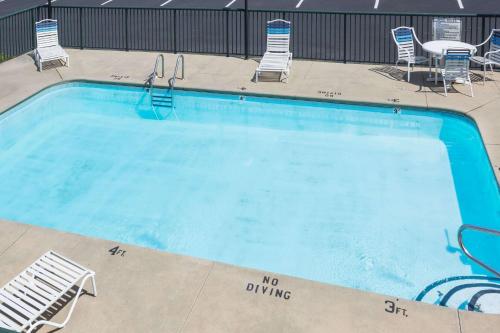 a large swimming pool with chairs and a table at Days Inn by Wyndham Sanford in Sanford