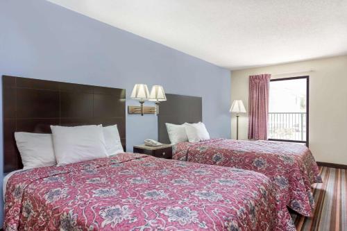 a hotel room with two beds and a window at Days Inn by Wyndham Sanford in Sanford