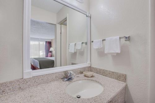 a bathroom with a sink and a mirror at Days Inn by Wyndham Asheville West in Candler