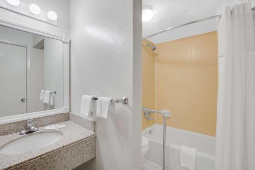 La salle de bains est pourvue d'un lavabo, d'une baignoire et d'une douche. dans l'établissement Days Inn by Wyndham Asheville West, à Candler
