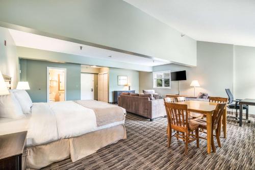 a hotel room with a bed and a living room at The Valley Inn, Ascend Hotel Collection in Waterville Valley