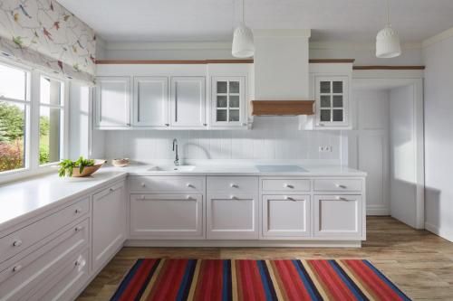 a kitchen with white cabinets and a colorful rug at Siedlisko Wnukowo in Szczechy Małe
