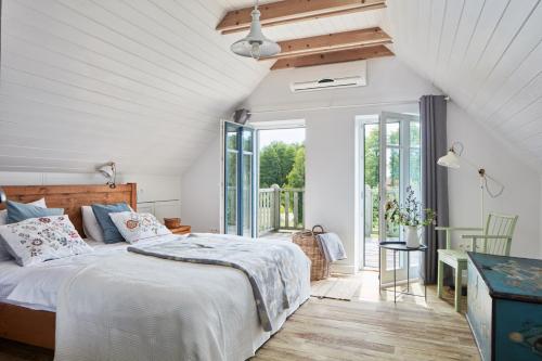 a bedroom with a bed and a balcony at Siedlisko Wnukowo in Szczechy Małe
