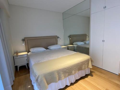 1 dormitorio con 1 cama grande y espejo en EXCLUSIVE PALERMO APARTMENT en Buenos Aires