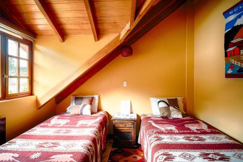two beds in the corner of a room at Casa de Luis in Otavalo