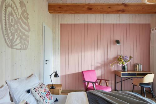 a bedroom with a pink wall with a desk and two chairs at Siedlisko Wnukowo in Szczechy Małe