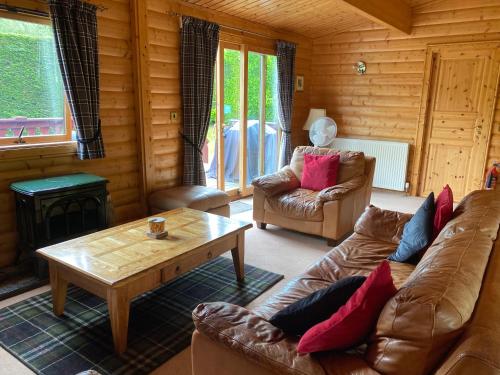 a living room with a couch and a coffee table at Kipplochan in Dalbeattie
