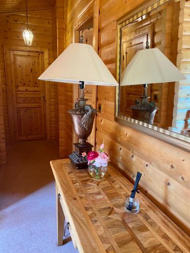 two lamps on a wooden table in a cabin at Kipplochan in Dalbeattie