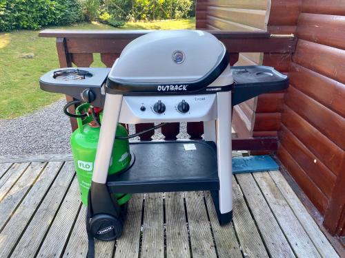 a gas grill sitting on a wooden deck at Kipplochan in Dalbeattie