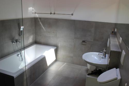a bathroom with a tub and a sink and a toilet at Ferienwohnung - Monteurunterkunft 31188 Holle in Holle