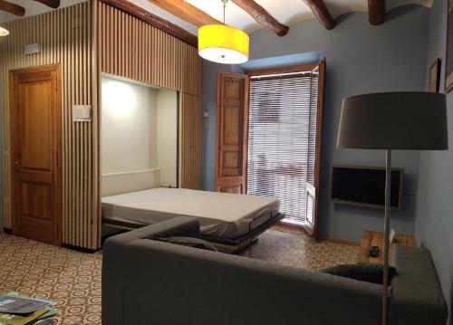 ein Wohnzimmer mit einem Bett und einem Sofa in der Unterkunft Apartaments Falset in Falset