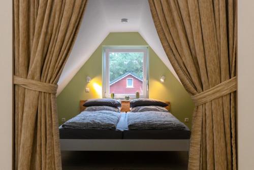 a bedroom with two beds in front of a window at Haus am See in Hermannsburg
