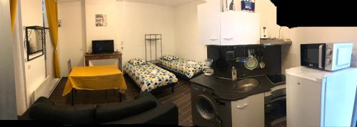 a room with a room with two beds and a tv at Studio Lit Séparé Tarbes Centre in Tarbes