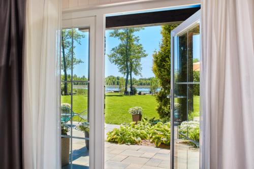 an open sliding glass door looking out onto a garden at Siedlisko Wnukowo in Szczechy Małe