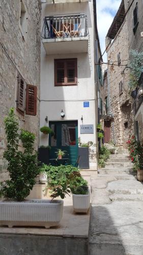 an alley with a building with a blue door at House Gorica in Šibenik