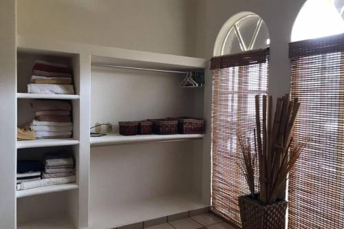 a bathroom with white shelves and a window with towels at Condo Acatlán in Santa Cruz Huatulco