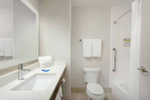 a white bathroom with a toilet and a sink at Holiday Inn Express - Tullahoma, an IHG Hotel in Tullahoma