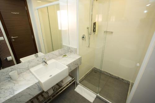 a bathroom with a sink and a shower at Royal Regency Palace Hotel in Rio de Janeiro