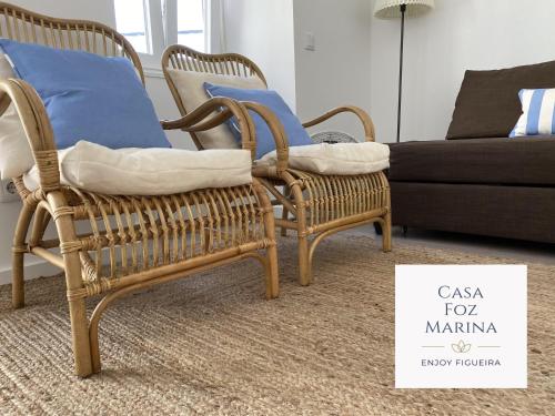 a pair of wicker chairs in a living room with a couch at Casa Foz Marina in Figueira da Foz