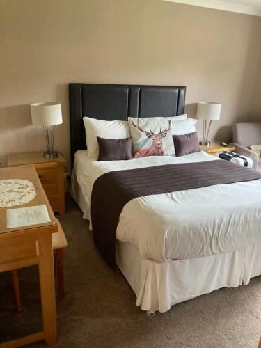 a bedroom with a large bed with a deer on it at Mayfield B&B in Fort William