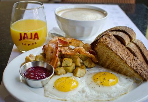 a plate of breakfast food with eggs bacon bread and toast at Hôtel Le Concorde Québec in Quebec City