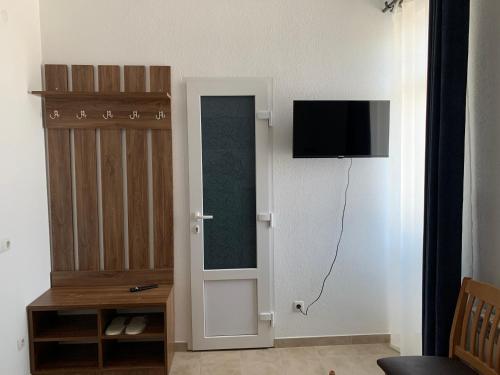 a living room with a tv and a door with a closet at ZIG ZAG in Kamianets-Podilskyi