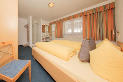 ゼルデンにあるApart Manuelaのベッドルーム(オレンジ色のカーテンが付いた大きな白いベッド付)