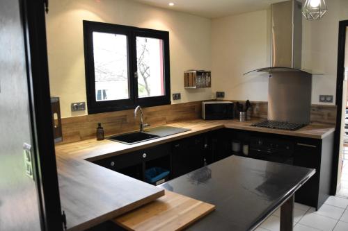 une cuisine avec un évier et une fenêtre dans l'établissement A la croisée des Meuniers à 5 mn du PUY du FOU, aux Épesses