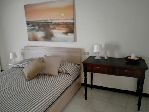 a bedroom with a bed with a desk and a painting at Oltre Mare in Sori