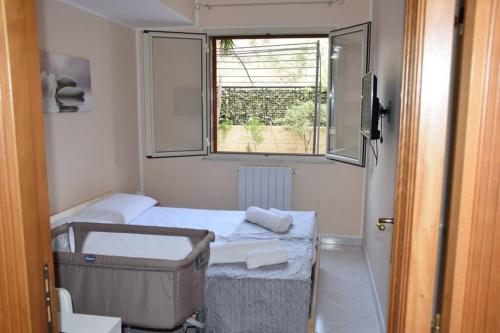 a small room with two beds and a window at Casa di Aida in Messina