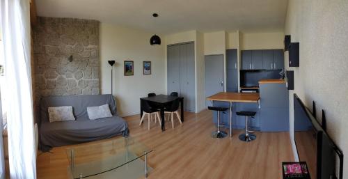 un salon et une cuisine avec un canapé et une table dans l'établissement Bel appartement 45m2 rez de chaussée plein sud, à Font-Romeu-Odeillo-Via