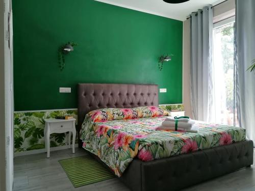 um quarto com paredes verdes e uma cama grande em Dimora Bed and Breakfast em San Gavino Monreale
