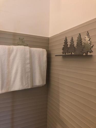 a bathroom with a towel and trees on a shelf at Relais Chalons d’Orange in Pescasseroli