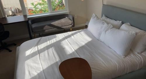 a bedroom with a large bed with white sheets and pillows at National at Dulles in Herndon