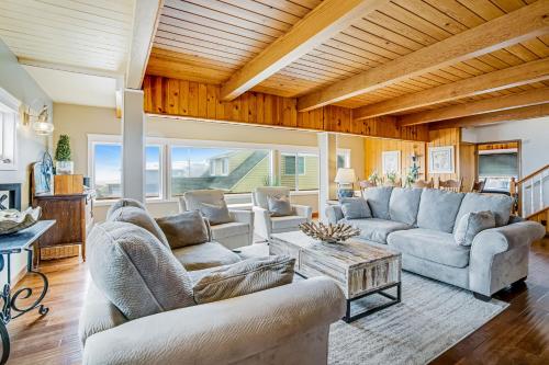 a living room with two couches and a table at Cozze Cottage in Wecoma Beach