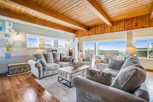 a living room with two couches and a table at Cozze Cottage in Wecoma Beach
