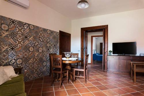 ein Esszimmer mit einem Tisch, Stühlen und einem TV in der Unterkunft Borgo San Lorenzello in San Lorenzello
