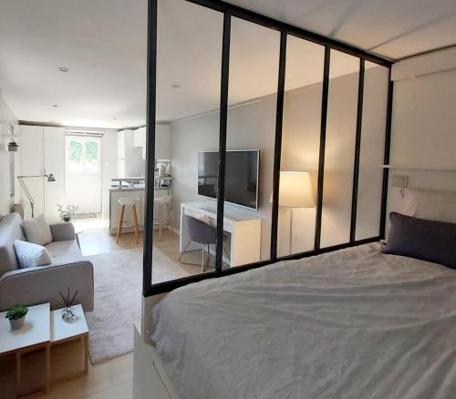 um quarto com uma cama grande e uma sala de estar em Charmant Studio sur cour à LYON 9e Mont d'or em Lyon