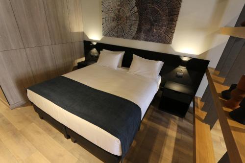 1 dormitorio con 1 cama grande con sábanas y almohadas blancas en Nucleo Mayor Apart, en Santiago