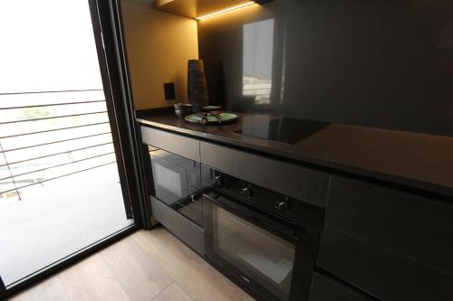 una cocina con encimera negra y fregadero en Nucleo Mayor Apart, en Santiago