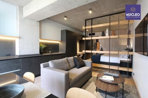 a living room with a couch and a bed at Nucleo Mayor Apart in Santiago