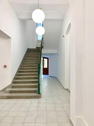 a staircase with a green pole in a white hallway at Residence Dlouha - Old Town in Prague