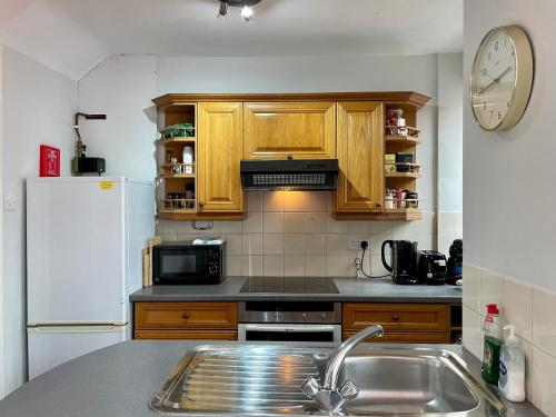 a kitchen with a sink and a white refrigerator at Somers 4 bed House off road parking pet friendly in Portsmouth