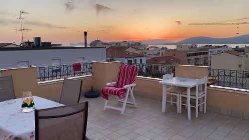 a balcony with tables and chairs and a view of a city at B&B Su Canistreddu in Alghero