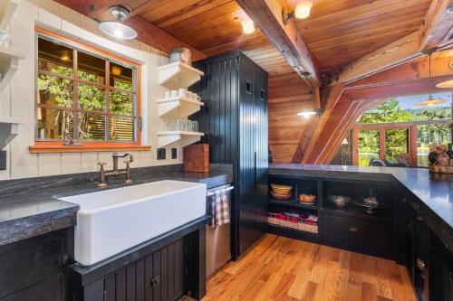 a kitchen with a white sink and a wooden ceiling at Serene Lakes Splendor in Soda Springs