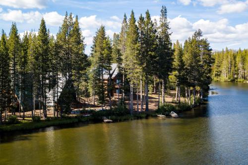 a house on the shore of a lake with trees at Serene Lakes Splendor in Soda Springs