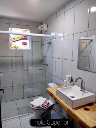 a bathroom with a toilet and a sink at A Nossa Casinha no Bosque - 4min do Parque Capivari in Campos do Jordão