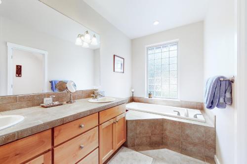 a bathroom with a tub and a sink and a bath tub at Pines and Blue Skies in Redmond