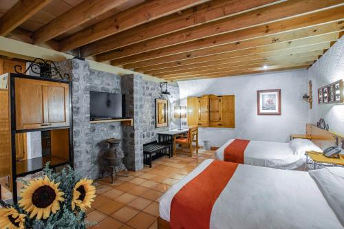 a bedroom with two beds and a desk in a room at Termas de San Joaquin in El Ranchito