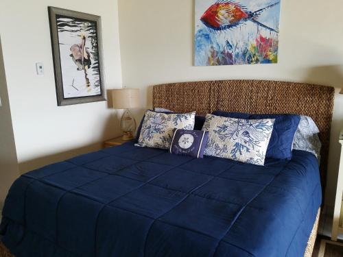 1 dormitorio con 1 cama con sábanas y almohadas azules en Luxury Sapphire Beach Resort and Marina 1BR VII, en East End